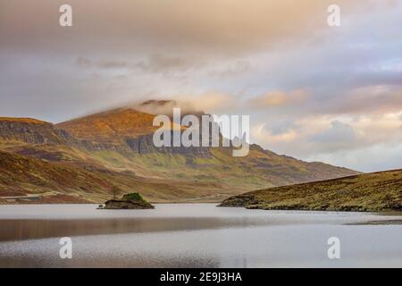 Isle of Skye, Schottland: Sonnenaufgang und Wolken über Loch Fada mit dem legendären Old man of Storr in der Ferne. Stockfoto