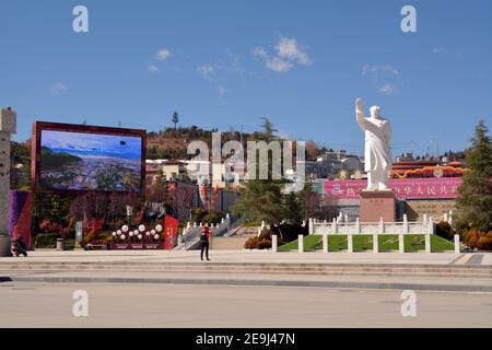 Tourist fotografiert eine Statue des PRC-Gründervorsitzenden Mao Zedong in einer Straße in Shangri La, Provinz Yunnan, China. Stockfoto