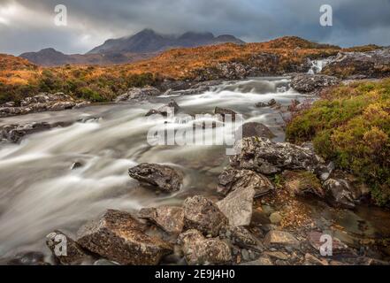 Isle of Skye, Schottland: Rauschende Gewässer des Flusses Sligachan mit brechenden Licht auf die Black Cuillin Mountains in der Ferne Stockfoto