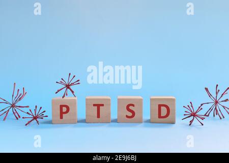 PTSD-Buchstaben in Holzblöcken auf blauem Hintergrund. Umgang mit Angst, Stress, ptsd und Depression während covid-19 Pandemie Konzept. Stockfoto