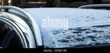 Schnee auf dem Dach des Autos. Das Auto ist mit Eis und Schnee bedeckt Stockfoto