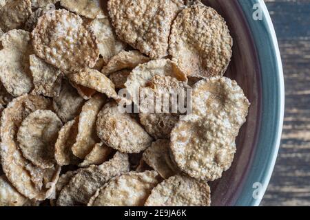 Vollkorn glasierte Flocken in Platte, Nahaufnahme, Draufsicht. Gesundes Frühstück, Vollkornmüsli in einer Schüssel Stockfoto