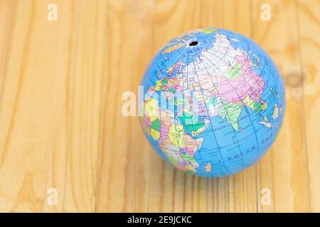 Globe auf Holzhintergrund - konzeptuelles Bild von Reisen und Geographie. Stockfoto