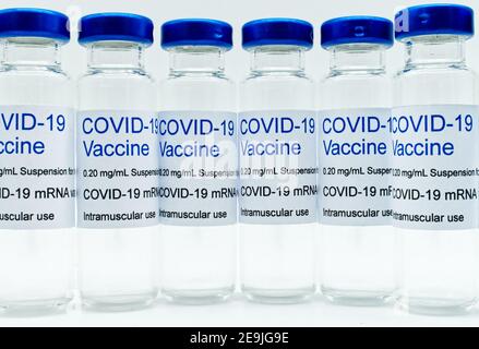 Transparente leere Glasfläschchen mit Covid-19-Impfstoffetiketten. Nahaufnahme Stockfoto