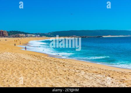 Die Menschen genießen einen sonnigen Tag an einem Strand in Nazare in Portugal Stockfoto