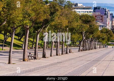 Portugal, Lissabon, 09. Oktober 2018: Gehweg mit Bäumen im Eduardo VII Park in der Nähe des Nelkenrevolution Denkmal und der Marquess of Pombal Platz in Stockfoto