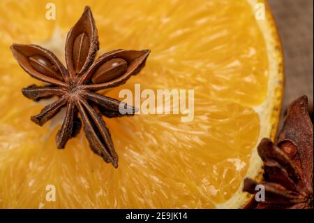 Eine halbe Orange und ein Sternanis auf einem Holztisch. Nahaufnahme, selektiver Fokus. Stockfoto