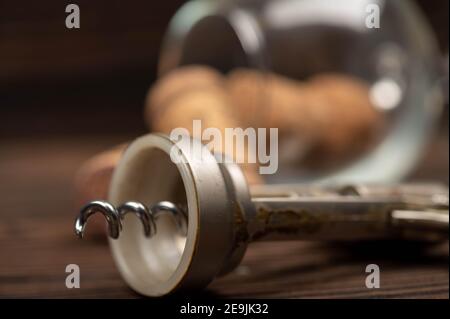 Korkenzieher und Korken aus Weinflaschen auf einem Holztisch. Nahaufnahme, selektiver Fokus. Stockfoto