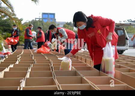 Peking, China. Februar 2021, 3rd. Mitarbeiter der lokalen Regierung verpacken lokale Spezialitäten in Shuibei Township der Stadt Xinyu, ostchinesische Provinz Jiangxi, 3. Februar 2021, bevor sie sie als chinesische Neujahrsgeschenke für Wanderarbeiter überreichen, die während der Frühlingsfesttage nicht nach Hause kommen werden. Quelle: Peng Zhaozhi/Xinhua/Alamy Live News Stockfoto