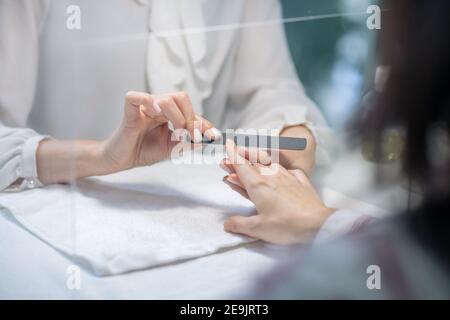 Nahaufnahme von Nagelkünstler Hände tun Maniküre Stockfoto