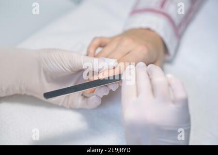 Nahaufnahme Bild von Nagelkünstler Hände Feilen Kunden Nägel Stockfoto