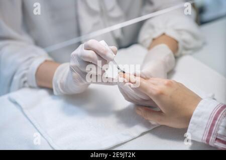 Nahaufnahme Bild von Nagelkünstler Hände Anwendung Nagelbasis Stockfoto