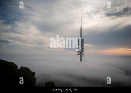 4. Februar 2021, Barcelona, Katalonien, Spanien: Der Telekommunikationsturm Torre de Collserola taucht auf dem Tibidabo-Hügel in Barcelona inmitten von Wolken und Nebel auf. Es wurde vom Architekten Sir Norman Foster entworfen und 1991 erbaut. Die obere Antenne erreicht 288,4 m (946 ft) und macht dies zum höchsten Gebäude in der katalanischen Gegend. Quelle: Jordi Boixareu/Alamy Live News Stockfoto