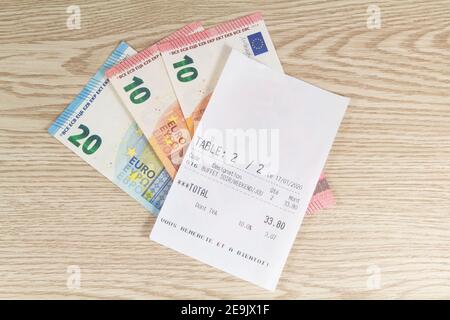 Euro-Banknoten und Restaurantrechnung auf einem Tisch Stockfoto