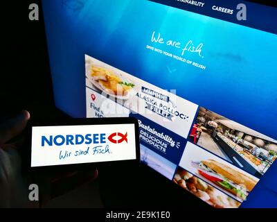 Person mit Smartphone mit Logo der deutschen Fast-Food-Restaurantkette Nordsee GmbH vor der Business-Website. Fokus auf Telefonbildschirm. Stockfoto