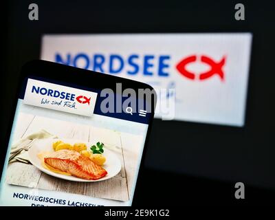 Handy mit Mahlzeit der deutschen Fast-Food-Restaurantkette Nordsee GmbH vor dem Firmenlogo. Konzentrieren Sie sich auf die obere Mitte des Telefonbildschirms. Stockfoto