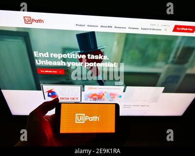 Person, die Smartphone mit Logo der Software-Entwicklung Firma UiPath Inc. Auf dem Display vor der Business-Webseite. Fokus auf Telefonbildschirm. Stockfoto