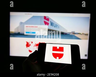 Person, die Smartphone mit Logo des deutschen Konzerns Würth (Befestigungselemente, Schrauben) vor der Website zeigt. Fokus auf Telefonbildschirm. Stockfoto