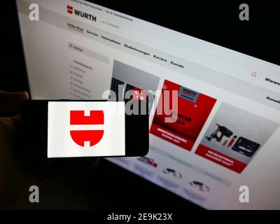 Hochwinkelansicht der Person, die Mobiltelefon mit Logo des deutschen Konzerns Würth hält, auf der Anzeige vor der Website. Konzentrieren Sie sich auf den Smartphone-Bildschirm. Stockfoto