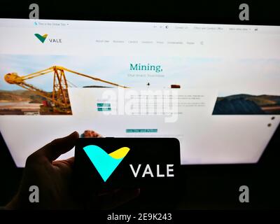 Person hält Smartphone mit Logo der brasilianischen Bergbau-und Logistikunternehmen Vale S.A. auf dem Display vor der Website. Fokus auf Telefonbildschirm. Stockfoto