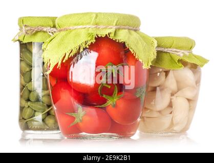 Kapern, Tomaten und Knoblauch in Glas isoliert auf weißem Hintergrund konserviert Stockfoto