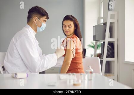 Arzt, der einer Frau einen Impfstoff gegen saisonale Grippe oder einen Ausbruch einer Infektion gibt. Stockfoto