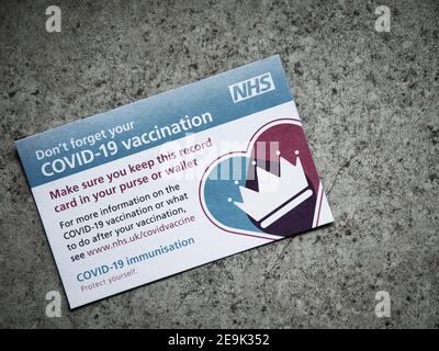 Eine UK NHS COVID-19 Impfkarte, verwendet, um Details der Impfungen gegeben zu protokollieren. Stockfoto