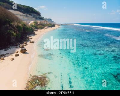 Luftaufnahme des tropischen Strandes mit türkisfarbenem Ozean in Bali, Melasti Strand Stockfoto