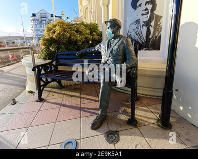 Statue der Norman Wisdom vor Sir Norman's Bar in Douglas, Isle of man mit einer Einweg-Gesichtsmaske hinzugefügt Stockfoto