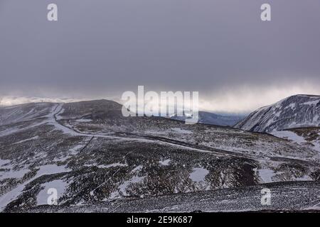 Blick auf die Ridgeline des Las Maol Mountain und die Berge dahinter bei Glenshee, mit einer leichten Schneedecke auf den Pisten. Stockfoto