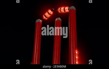 Rote elektronische Cricket-Wickets mit ausrichtenden Bällen und Beleuchtung LED Lichter auf dem Hintergrund des Nachthimmels - 3D Rendern Stockfoto