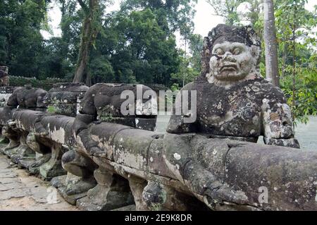 Alte Khmer Statuen von Asuras, oder Teufel, ziehen die Naga Schlange über den Graben des Preah Khan Temple, Siem Reap. Stockfoto