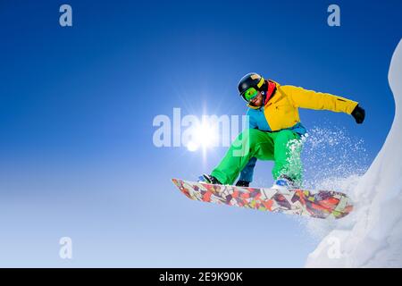 Snowboarder Jumping on Snowboard in den Bergen. Snowboarden und Wintersport Stockfoto