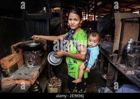 Alltag der Flüchtlinge im IDP-Flüchtlingslager Shatapru in Myikyina, Myanmar. Jede Familie hat ein Zimmer in den armen Hütten. Stockfoto