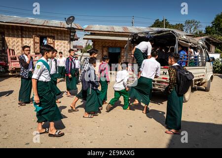 Die Schüler, von denen die meisten Waisenkinder sind, die aus dem Bürgerkrieg geflohen sind, werden in Myikyina, Myanmar, wieder zur staatlichen Schule gefahren. Stockfoto