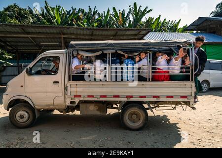 Die Schüler, von denen die meisten Waisenkinder sind, die aus dem Bürgerkrieg geflohen sind, werden in Myikyina, Myanmar, wieder zur staatlichen Schule gefahren. Stockfoto