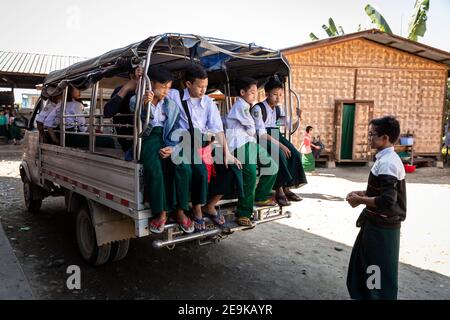 Die Schüler, von denen die meisten Waisenkinder sind, die aus dem Bürgerkrieg geflohen sind, werden in Myikyina, Myanmar, wieder zur staatlichen Schule gefahren. Stockfoto