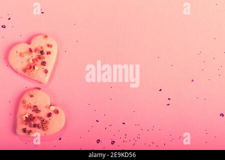 Valentinstag herzförmige Kekse trocknen Erdbeeren auf rosa Hintergrund mit Konfetti. Draufsicht. Speicherplatz kopieren. Liebe Konzept, Valentinstag behandelt Stockfoto