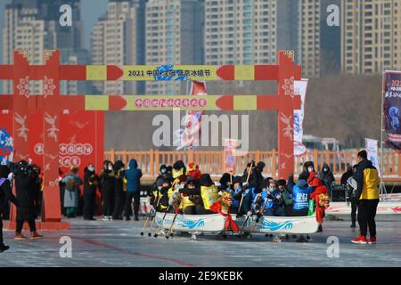 Foto zeigt, dass Menschen am Wettbewerb der Eisdrachenboote in der Stadt Shenyang, nordöstlich der Provinz Liaoning, 2. Februar 2021 teilnehmen. Das Shenyang International Ice Dragon Boat Race 3rd startete am Dienstag in Shenyang, um den Wintersport zu fördern. Stockfoto