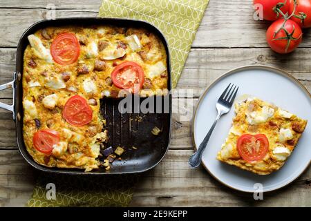 Eine frisch zubereitete Ziegenkäse-Frittata. Die volle Frittata wird in der Pfanne mit einer Einteilerscheibe angezeigt. Eine Option für gesunde Ernährung auf Ei-Basis Stockfoto
