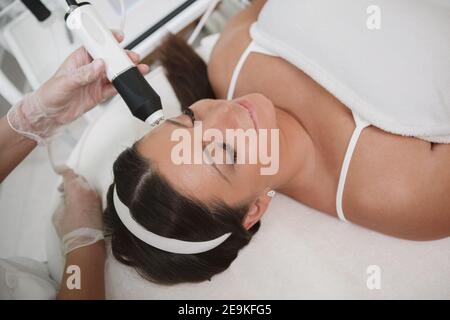 Entspannte Frau genießen professionelle Gesichtsbehandlung von Kosmetikerin Stockfoto