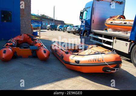 RNLI neue Rettungsboote werden entladen Northumberland Marke Schlauchboot LKW Entladung Lieferung geparkt orange rettet Leben Leben retten Küstenwache UK Stockfoto