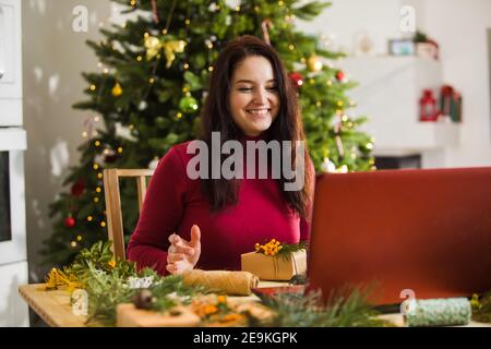 Frau begrüßt ihre Freunde online am Silvesterabend Stockfoto