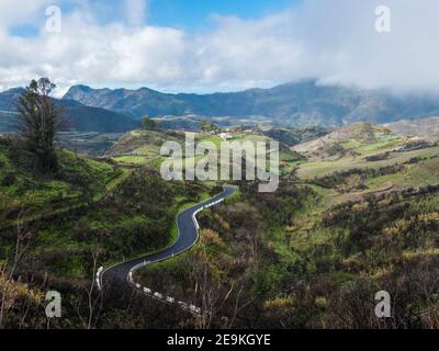 Blick auf das wunderschöne Hinterland von Gran Canaria und die grünen Hügel mit gewundener Asphaltstraße. Kanarische Inseln, Spanien Stockfoto