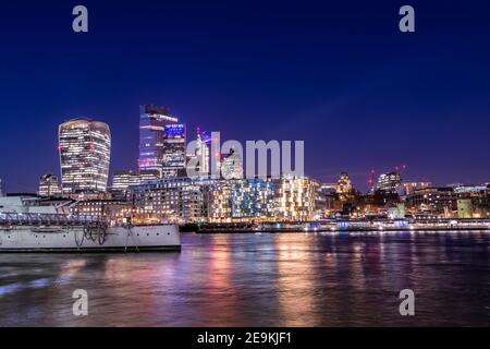 London Stadtbild bei Nacht Blick auf die City of London von der anderen Seite der Themse, Nachtleben in der britischen Hauptstadt, viele Lichter und Reflexionen in Stockfoto