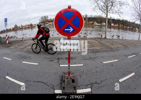 05. Februar 2021, Sachsen, Pirna: Ein Radfahrer fährt auf dem Elbradweg, während ein Schild auf eine Rastzone wegen der Überschwemmung der Elbe hinweist. Wegen des hohen Wassers haben einige Plätze bereits geschlossene Parkplätze an den Ufern. Foto: Daniel Schäfer/dpa-Zentralbild/dpa Stockfoto