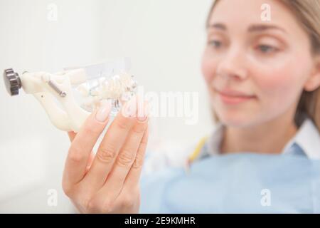 Selektiver Fokus auf zahnmedizinisches Modell mit Zahnspangen in der Hand Der jungen Frau Stockfoto