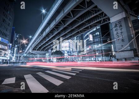 Eine belebte Kreuzung unter einer erhöhten Autobahn bei Nacht in der Nähe von Umeda in Kita-ku, Osaka, Japan Stockfoto