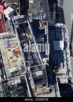 Luftaufnahme der Bauarbeiter auf einem hohen Gebäude von oben gesehen Stockfoto