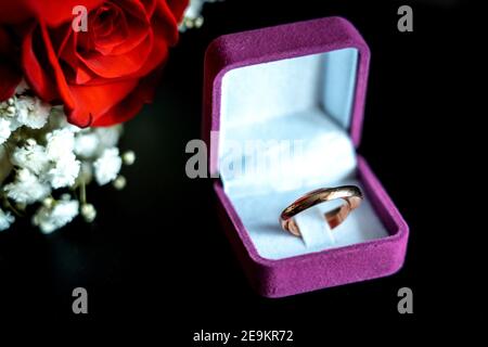 Trauringe im Fall für Ringe mit roter Rose. Ehe und Hochzeit-Konzept-Bild. Stockfoto